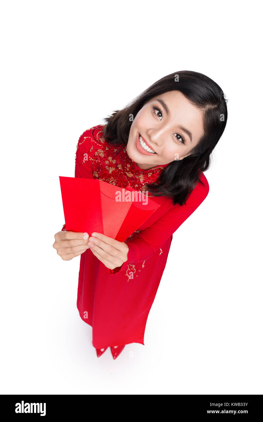 Portrait d'une belle femme asiatique sur festival traditionnel costume Ao Dai holding red pocket - la chance de l'argent. Du Têt. Le Nouvel An lunaire. Banque D'Images