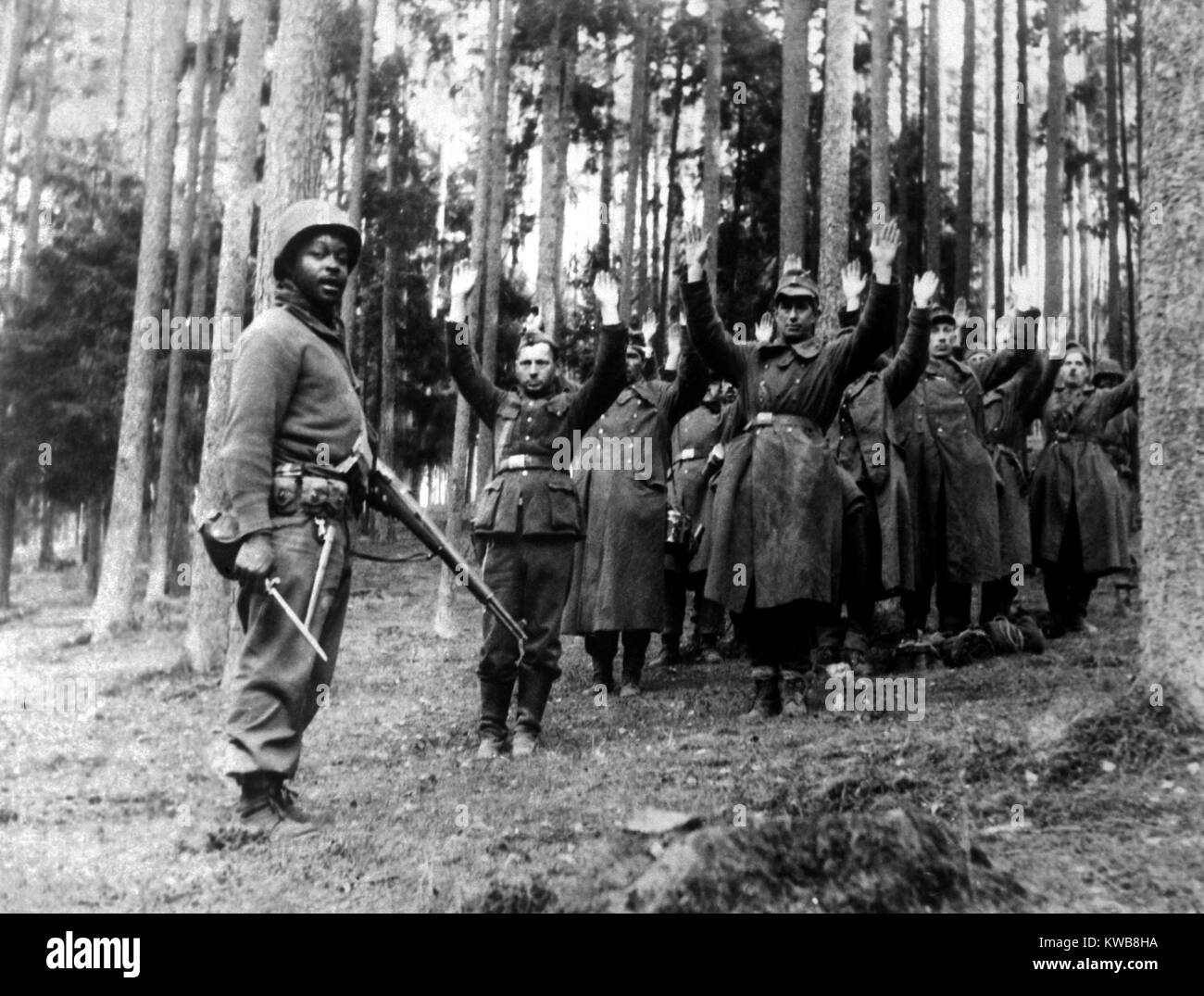 Un soldat afro-américain de la monte la garde sur un groupe de prisonniers nazis. Les Allemands ont été capturés dans la forêt environnante par les États-Unis 12e Division blindée, avril 1945, la Première Guerre mondiale 2. (BSLOC 2014 8 95) Banque D'Images