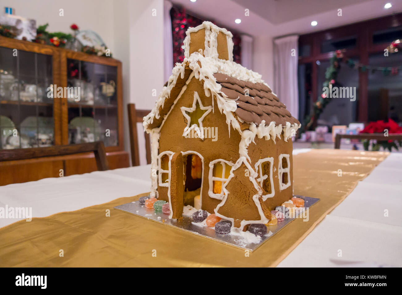 A Gingerbread House Hotel est fier de la place debout au milieu d'une table de salle à manger. Banque D'Images