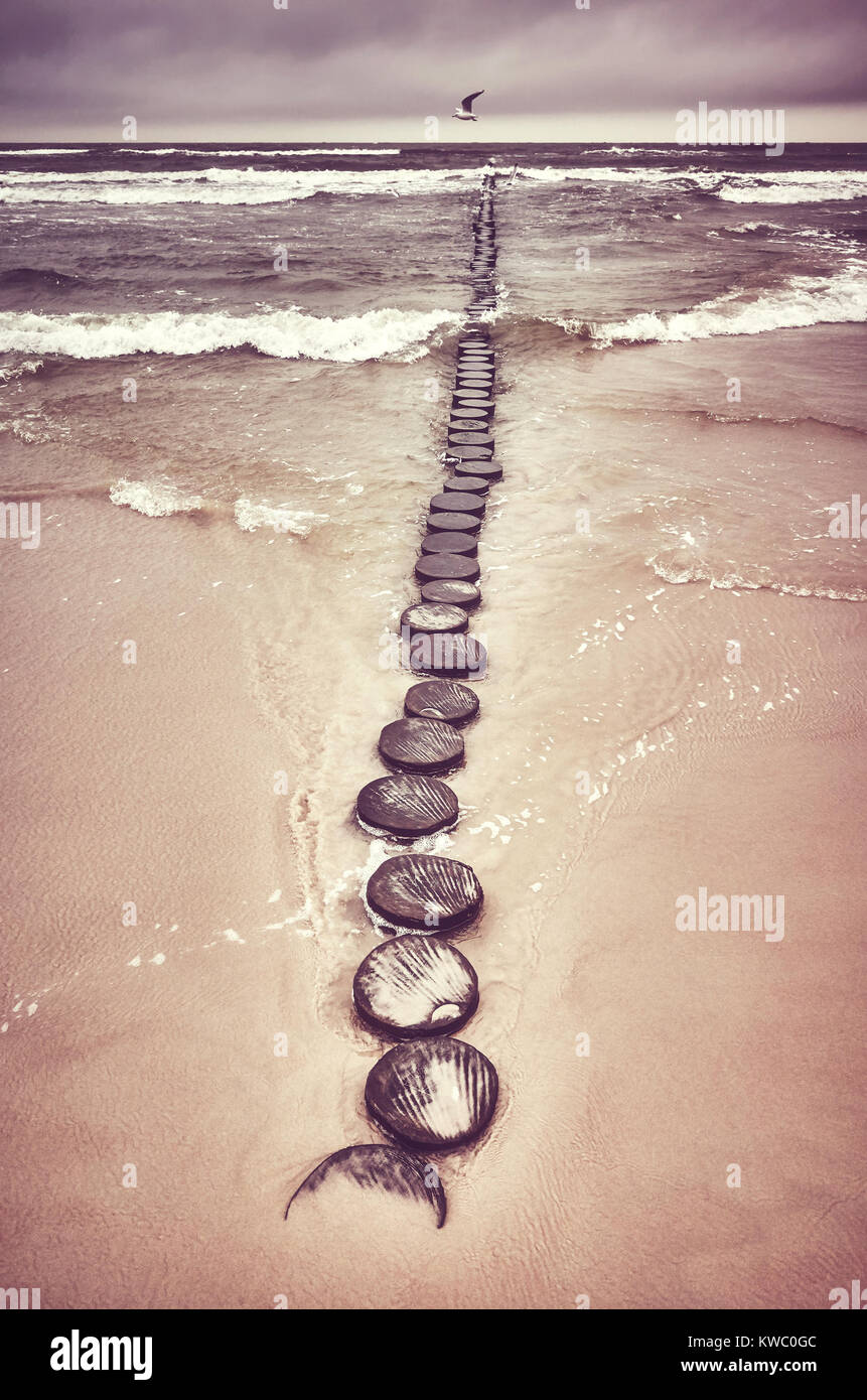 Retro photo aux couleurs d'une ancienne jetée en bois sur une plage. Banque D'Images