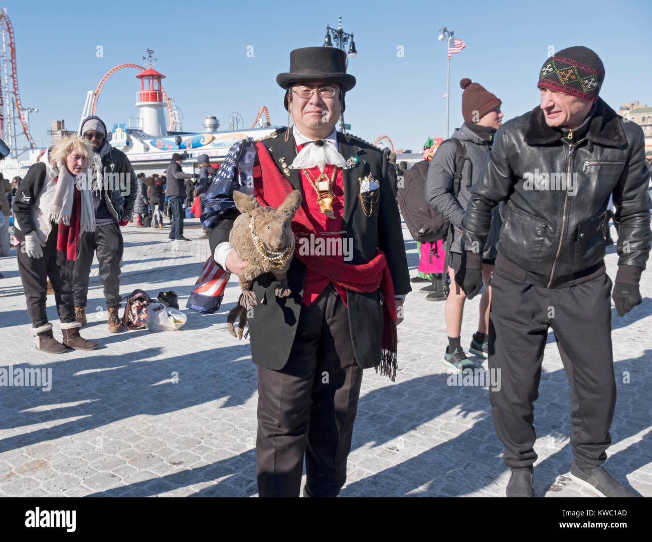 Un homme d'origine asiatique avec un lapin en peluche sur la promenade à la 114e Polar Bear Club le jour de l'an nager. Banque D'Images