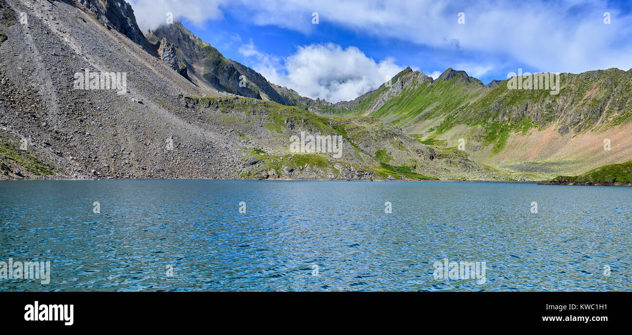 Surface bleue de lac de montagne et d'éboulis de pierre tomber dans l'eau. Highlands de l'Est de Sayan. La Russie Banque D'Images