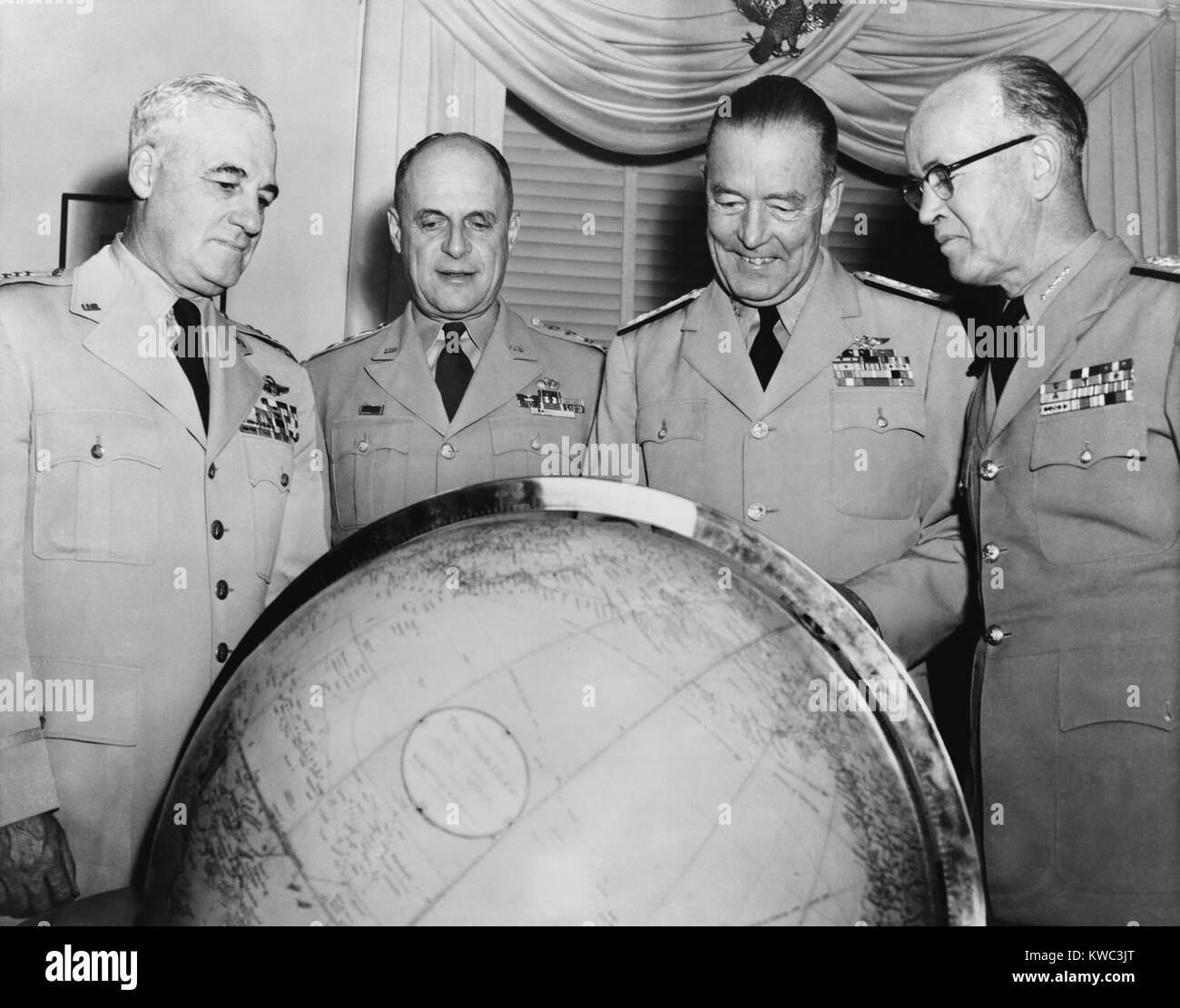 Forces armées américaines chefs d'état major interarmées sous le président Eisenhower, 1953. Posés à la recherche à un globe, L-R : Nathan F. Twining, le général Matthew Ridgeway, l'amiral Arthur Radford et de l'amiral Robert B. Carney. (BSLOC___2015 14 126) Banque D'Images