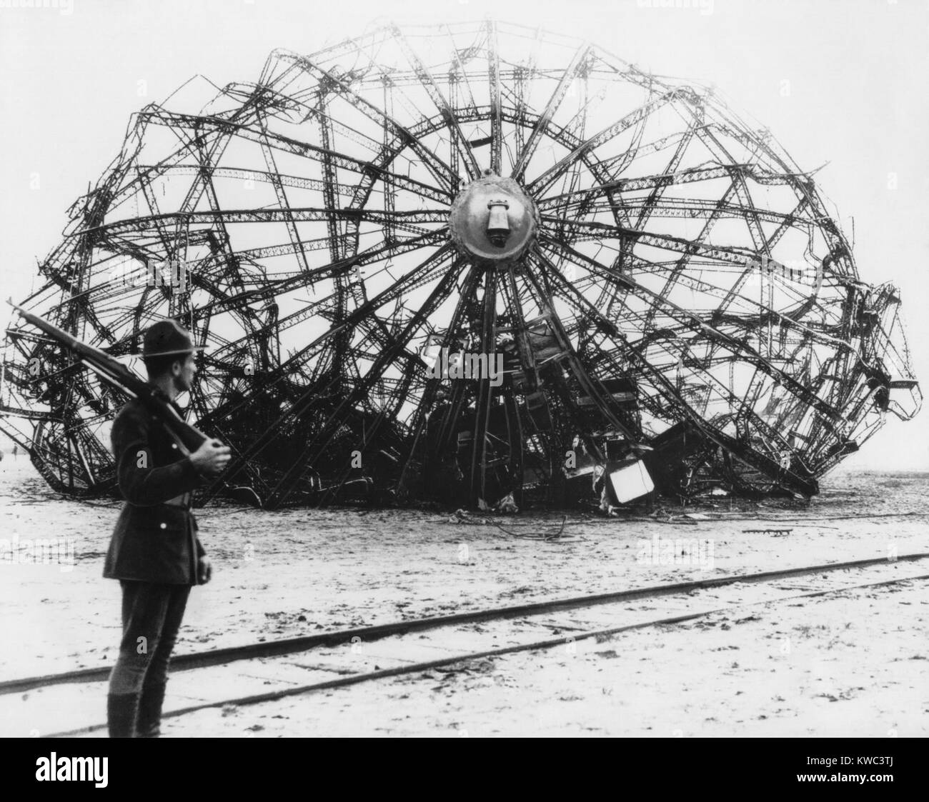 Épave de l'Hindenburg gardés par un soldat à la Naval Air Station à Lakehurst, New Jersey. mai 1937. Le dirigeable allemand's twisted metal skeleton demeure. (BSLOC   2015 14 189) Banque D'Images