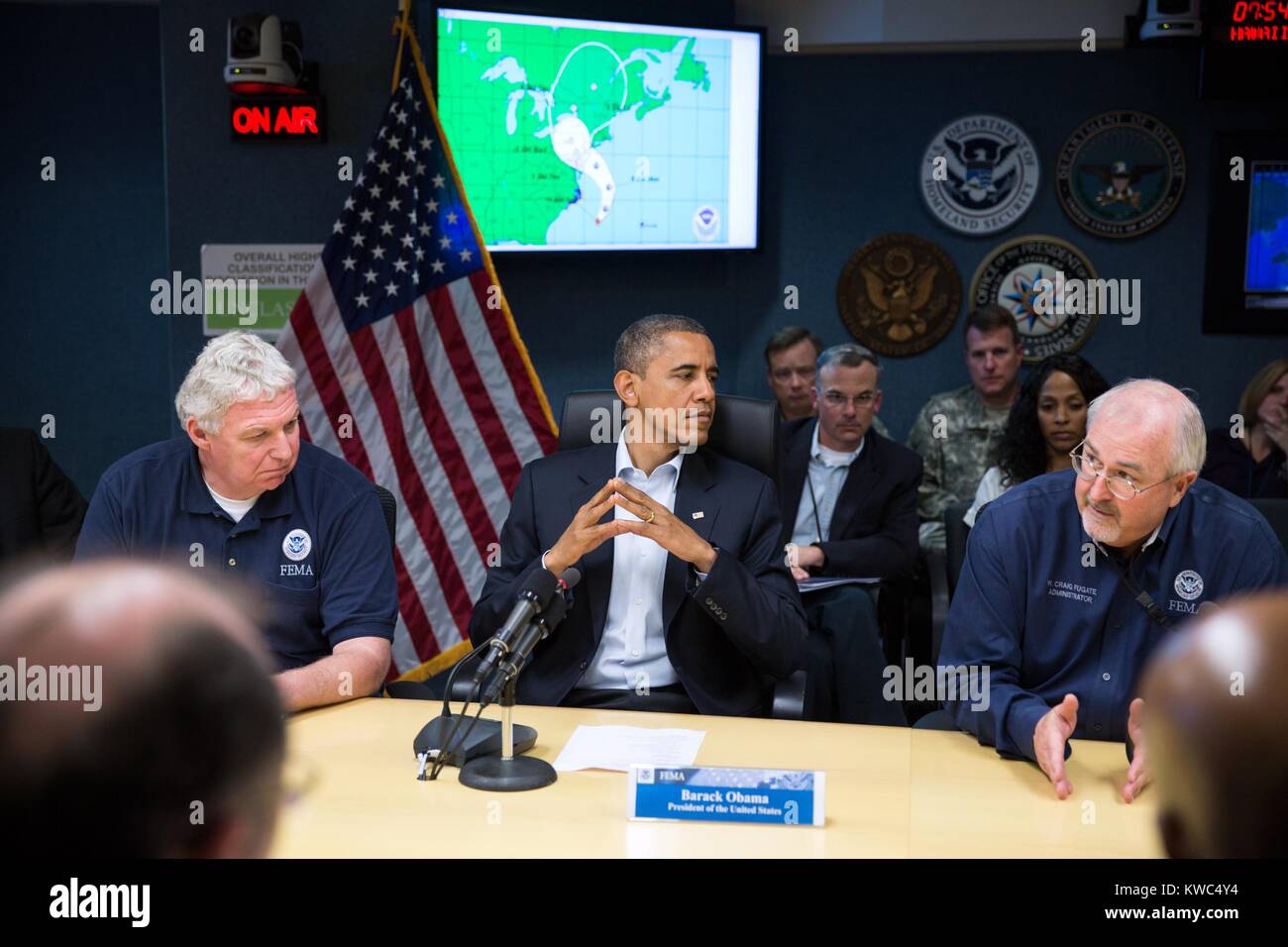 Le président Obama au QG de la FEMA pendant l'Ouragan Sandy, le 28 octobre 2012. Assis avec le président de la FEMA sont Administrateur adjoint Richard Montoro Inferiore, à gauche, et l'administrateur de la FEMA Craig Fugate. (BSLOC   2015 13 169) Banque D'Images