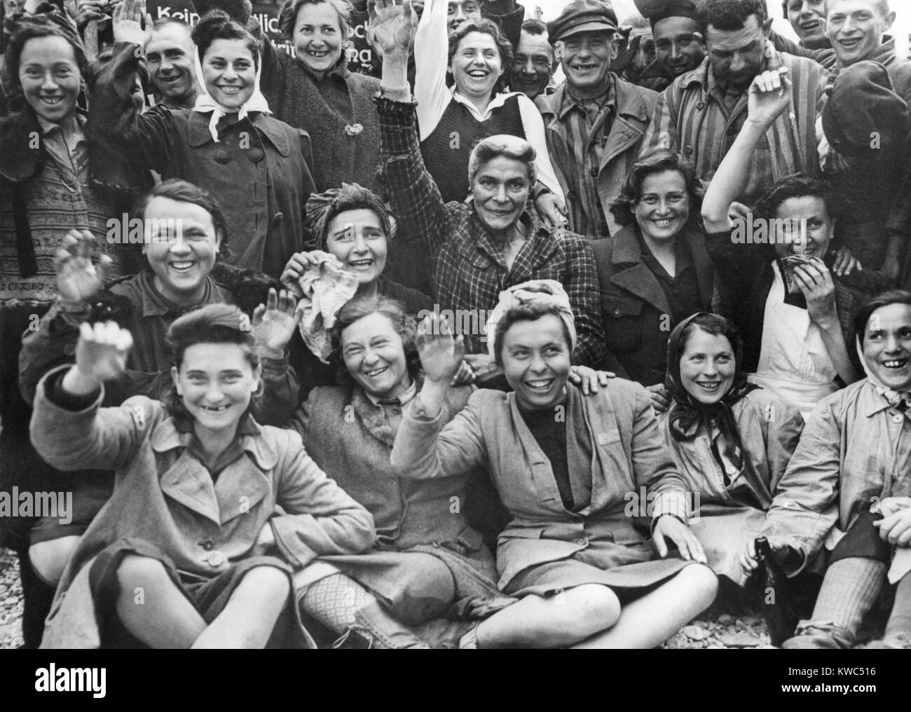 Les prisonnières libérées au camp de concentration de Dachau vague et bravo pour un portrait de groupe. Photo a été prise par le photographe américain Signal Corps, ca. 29 avril 1945, la Première Guerre mondiale (BSLOC 2  2015 13 22) Banque D'Images