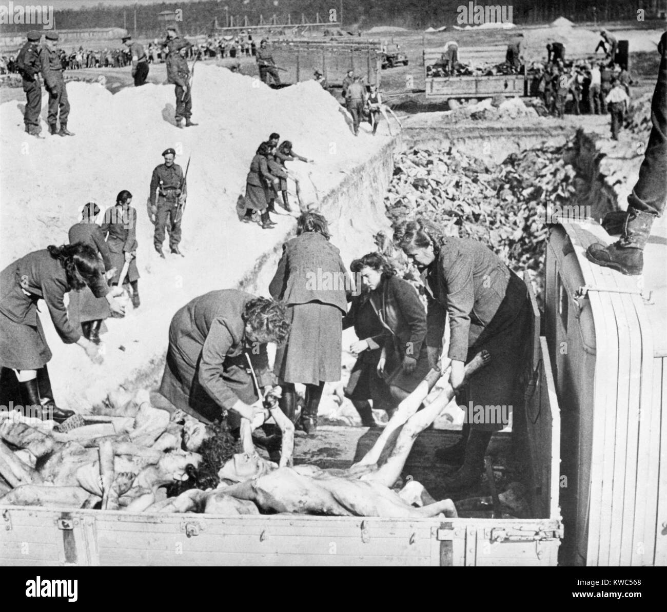 Les femmes SS nazis enlever les gardes corps des victimes d'un camion au cours de l'enfouissement au camp de concentration de Belsen. British solders guard et supervise le travail. Avril 1945, la Première Guerre mondiale (BSLOC 2015 2 13 8) Banque D'Images