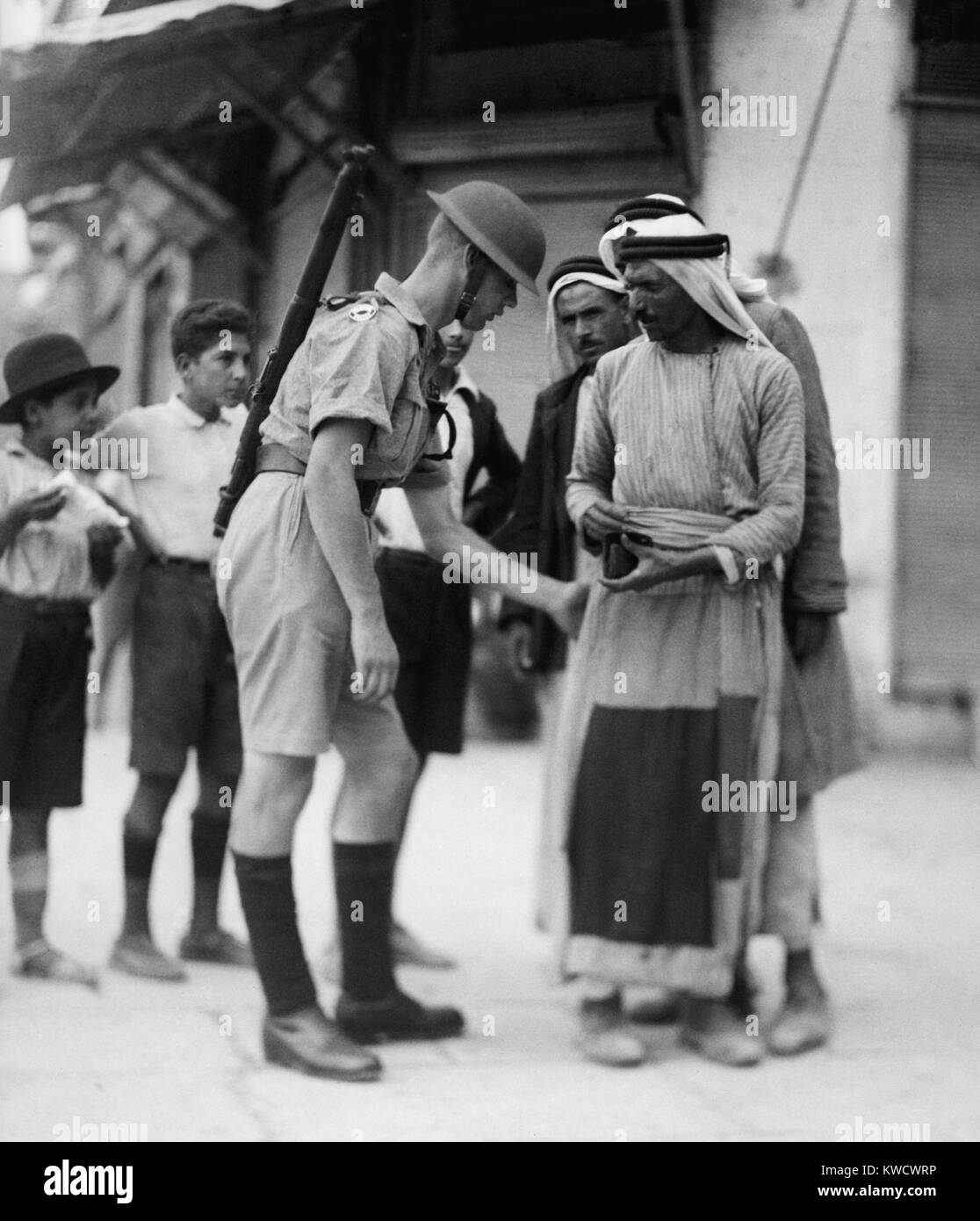 Soldat britannique contrôle de papiers et d'armes pour les Arabes de la recherche à la porte de Jaffa, Jérusalem. 1936 pendant la révolte arabe (BSLOC 2017 1 203) Banque D'Images