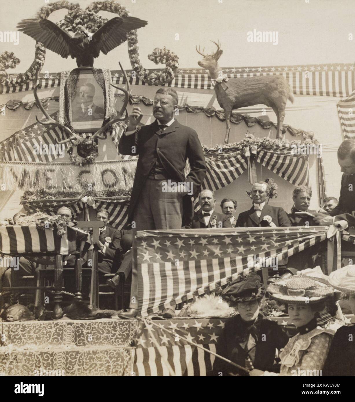 Le président Theodore Roosevelt un discours, Newcastle, le Wyoming, le 25 avril 1903. Actions TR la scène avec Canada deer, cerf cerf, bearskin rug et Eagle (BSLOC_2017_4_73) Banque D'Images