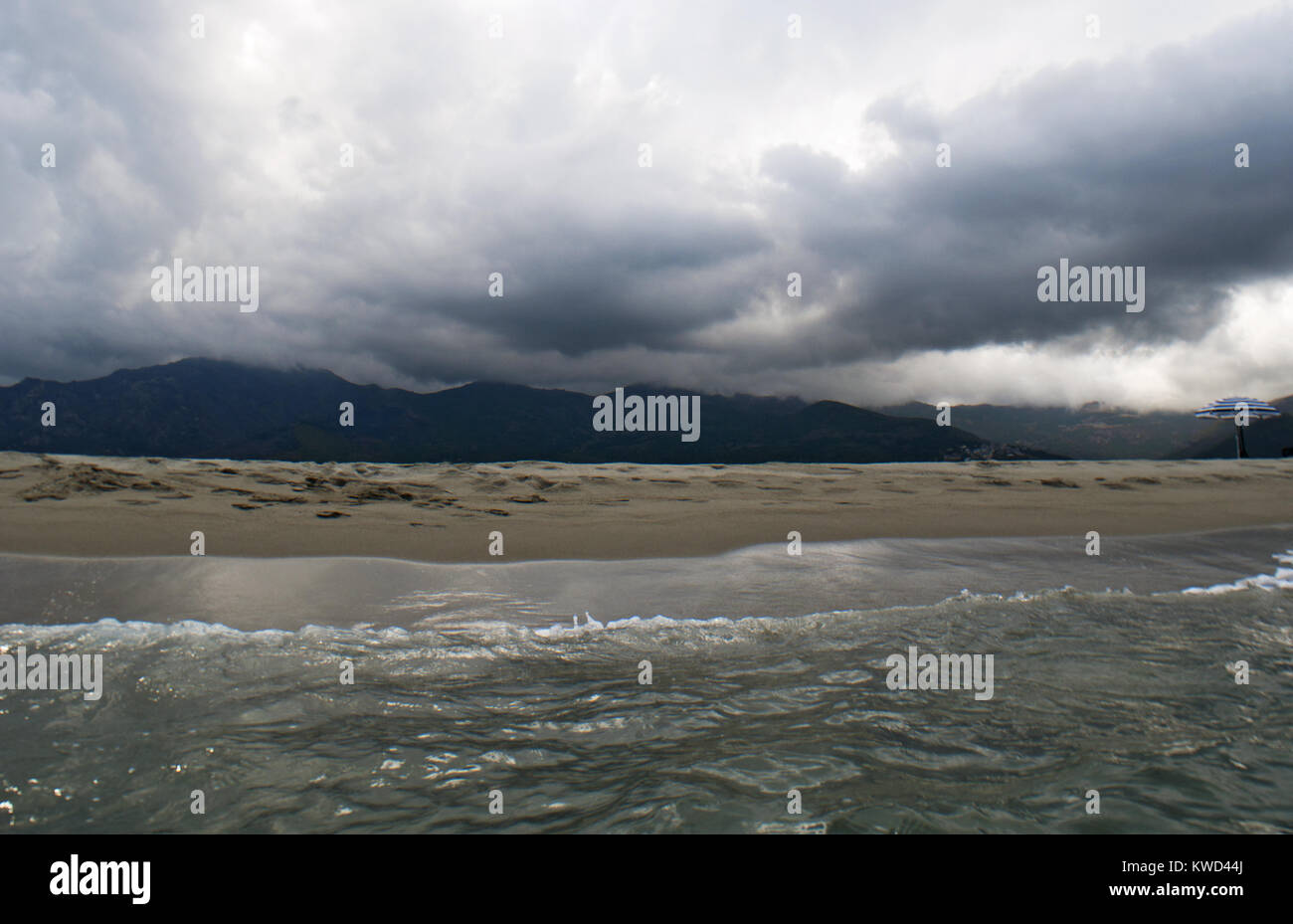 Corse : tempête sur la plage de Furiani, petite ville de la Haute Corse, avec des nuages de pluie et la mer Tyrrhénienne, rugueux Banque D'Images