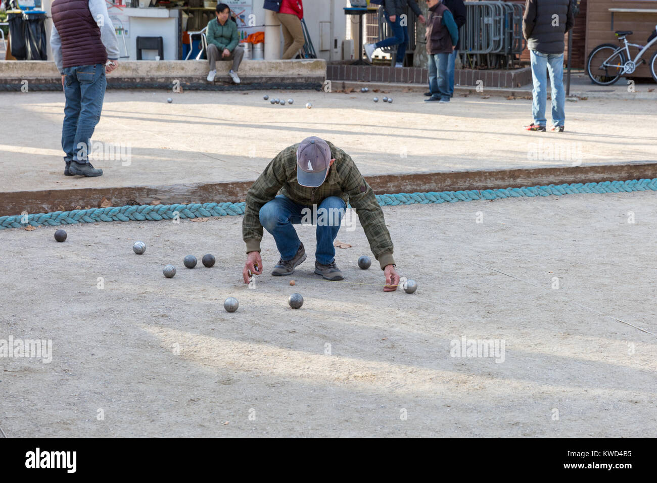 L'homme de prendre des mesures au cours du traditionnel jeu de boules ball français, ou de pétanque, à Cannes, Côte d'Azur, France Banque D'Images