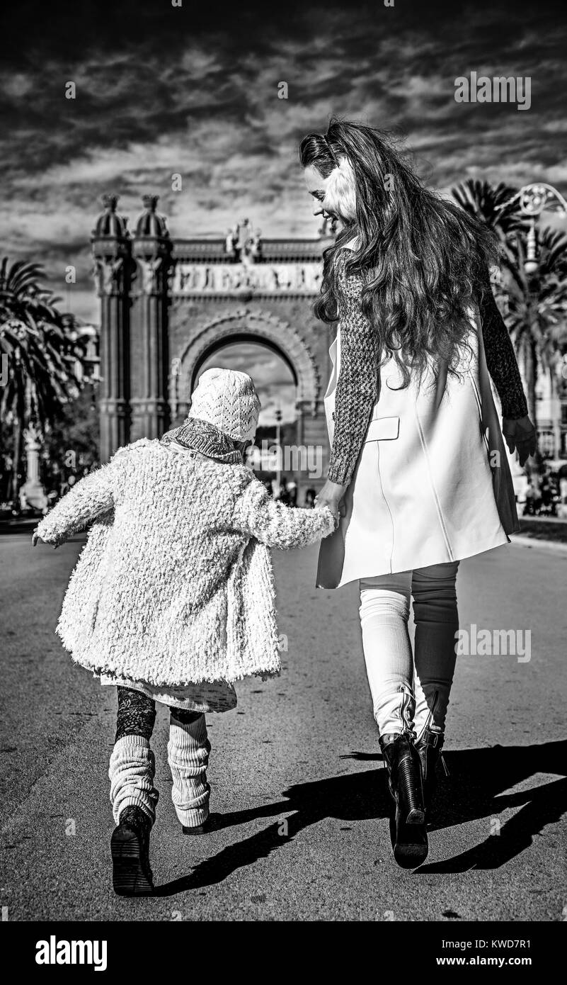 À Barcelone pour un hiver parfait. Vus de derrière, la mère et la fille moderne à Barcelone, Espagne la marche Banque D'Images