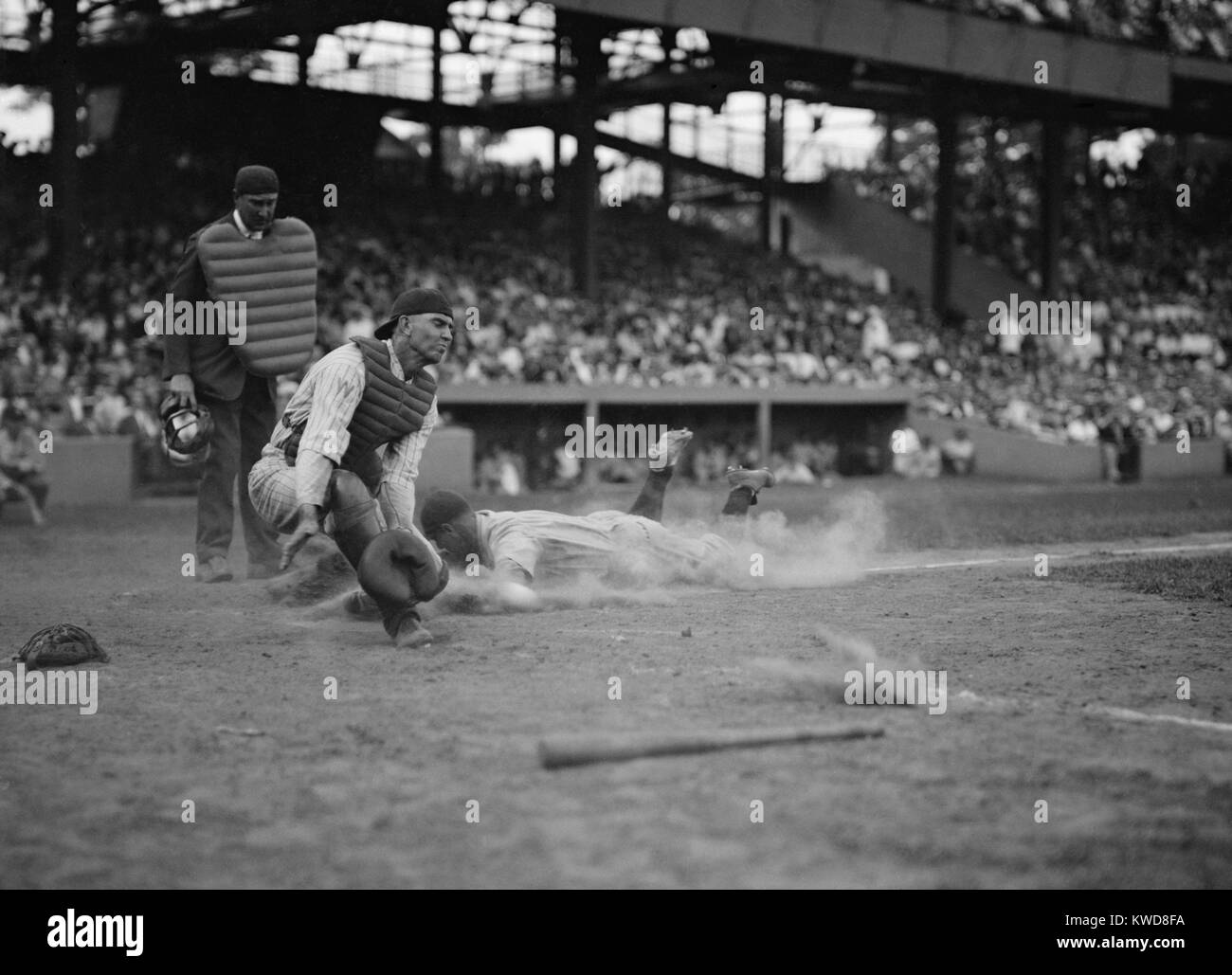 Lou Gehrig des Yankees notes comme Joe Harris' jeter s'éloigne de catcher Hank Severeid des sénateurs. New York Yankees battre Washington, les sénateurs 3-2. 16 août 1925. (BSLOC 2015 17 6) Banque D'Images