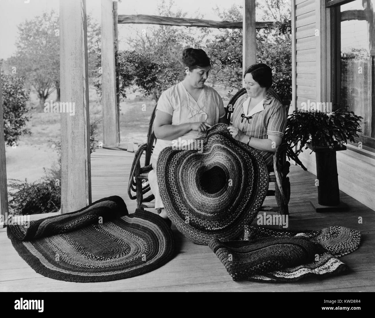 Deux femmes faire tapis de chiffon sur le porche, 1925-1930. Ces revêtements de sol ont été faites à partir de restes de tissus et vêtements usés, le recyclage matière dans l'artisanat folk américaine fonctionnelle (BSLOC 2016 8 108 ) Banque D'Images