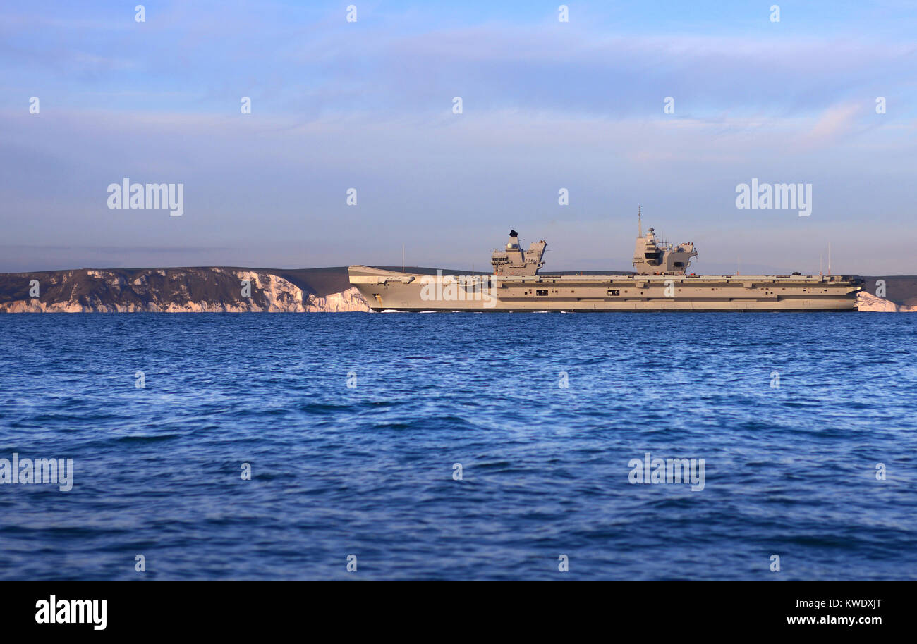 La Royal Navy porte-avions HMS Queen Elizabeth arrive au coucher du soleil à Portland, Dorset, sur la côte jurassique Banque D'Images