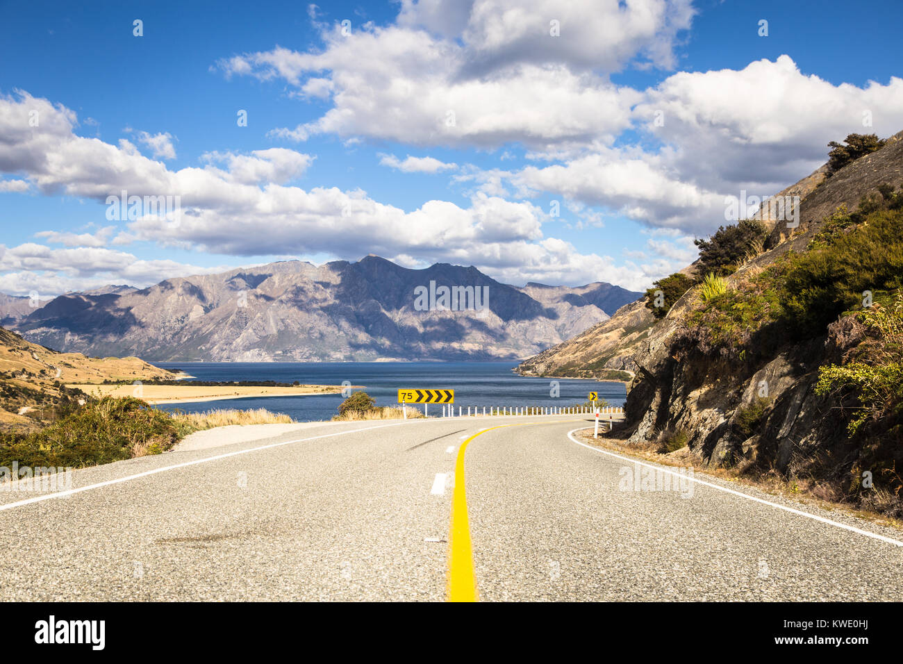 Sur la route entre le lac Hawea, dans l'arrière-plan, et le lac Wanaka, près de la ville touristique de Wanaka à Canterbury, district de la Nouvelle-Zélande île du sud. Banque D'Images