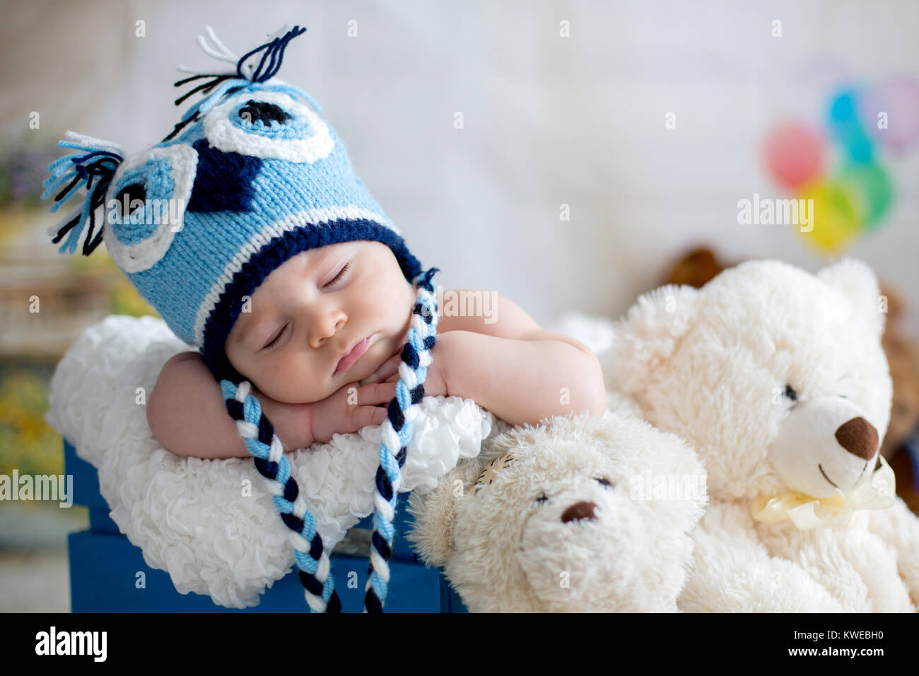 Petit bébé garçon avec Chapeau tricoté, dormir avec mignon ours en peluche jouet à la maison Banque D'Images