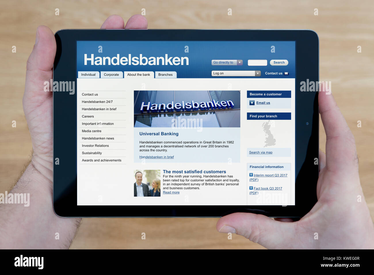 Un homme regarde le Svenska Handelsbanken site sur son iPad tablet device, tourné contre une table en bois page contexte (usage éditorial uniquement) Banque D'Images