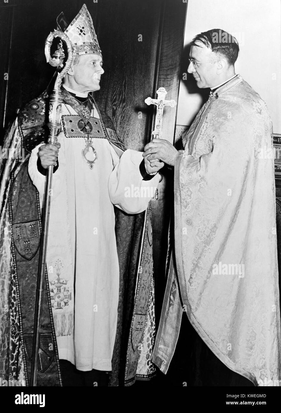 14 Juin 1944.Le Très Révérend William T. Manning, évêque de la diocèse épiscopale protestante de New York, présente une croix d'argent au très révérend J. Shoukletovich Doushan, doyen de la cathédrale de Saint Sava, à New York, ils ont d'abord la cathédrale orthodoxe serbe d'être établi aux États-Unis. La présentation faisait partie de la cérémonie de dédicace de l'église dans laquelle des milliers d'Américains et de Canadiens d'origine serbe qui y ont participé. Banque D'Images