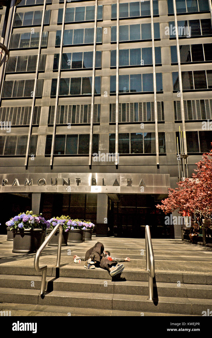 Personne sans-abri allongé sur le sol en face de Paramount Plaza sur Broadway Banque D'Images