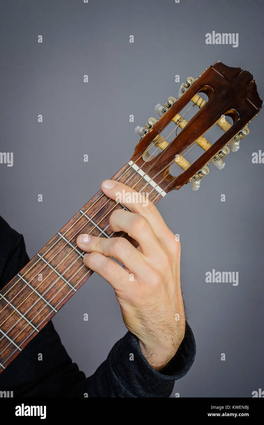 Le guitariste jouant un Bb d'accord sur une guitare acoustique classique avec des cordes en nylon Banque D'Images