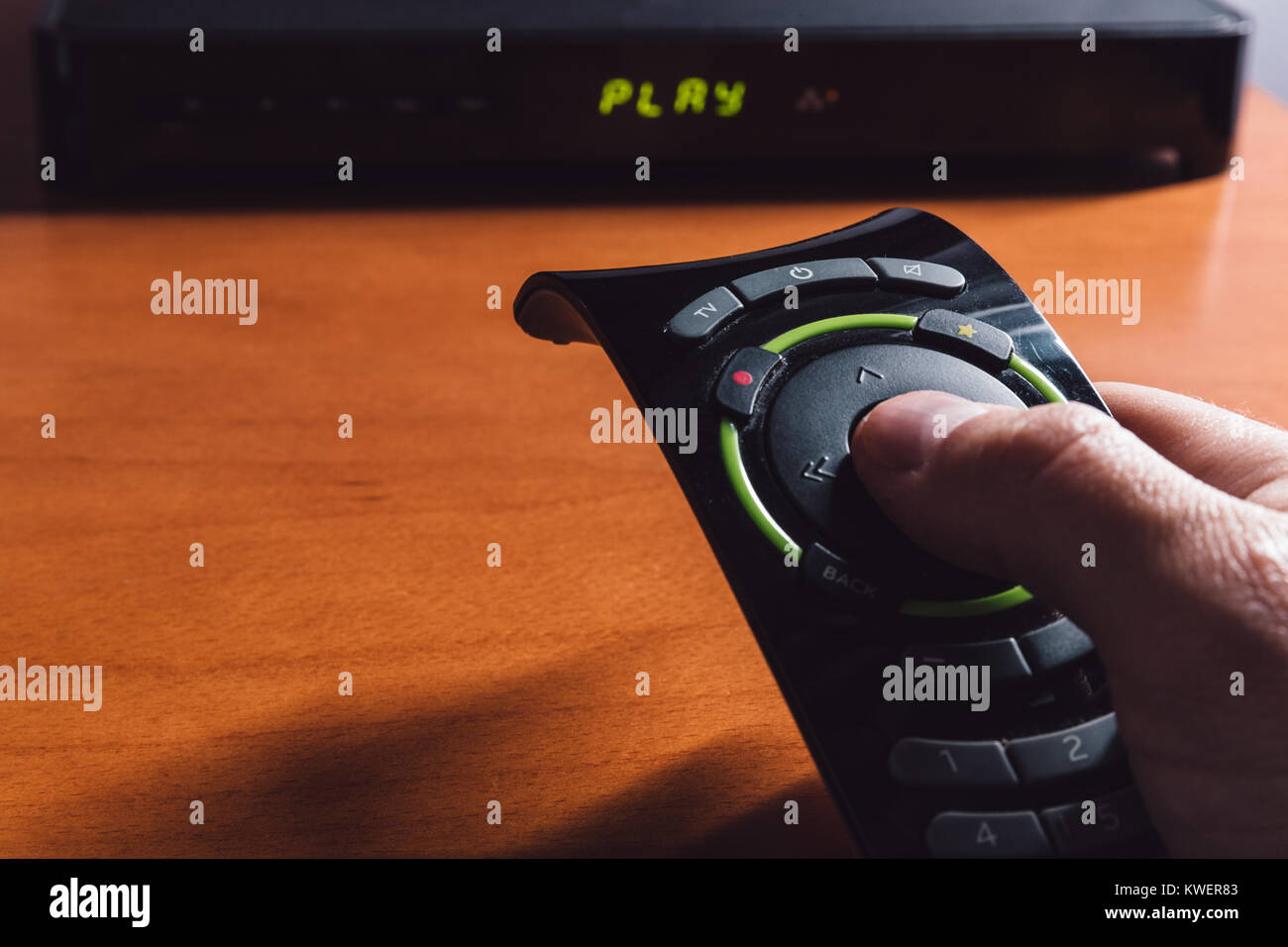 Homme pointant la télécommande du téléviseur pour la TV Box Banque D'Images