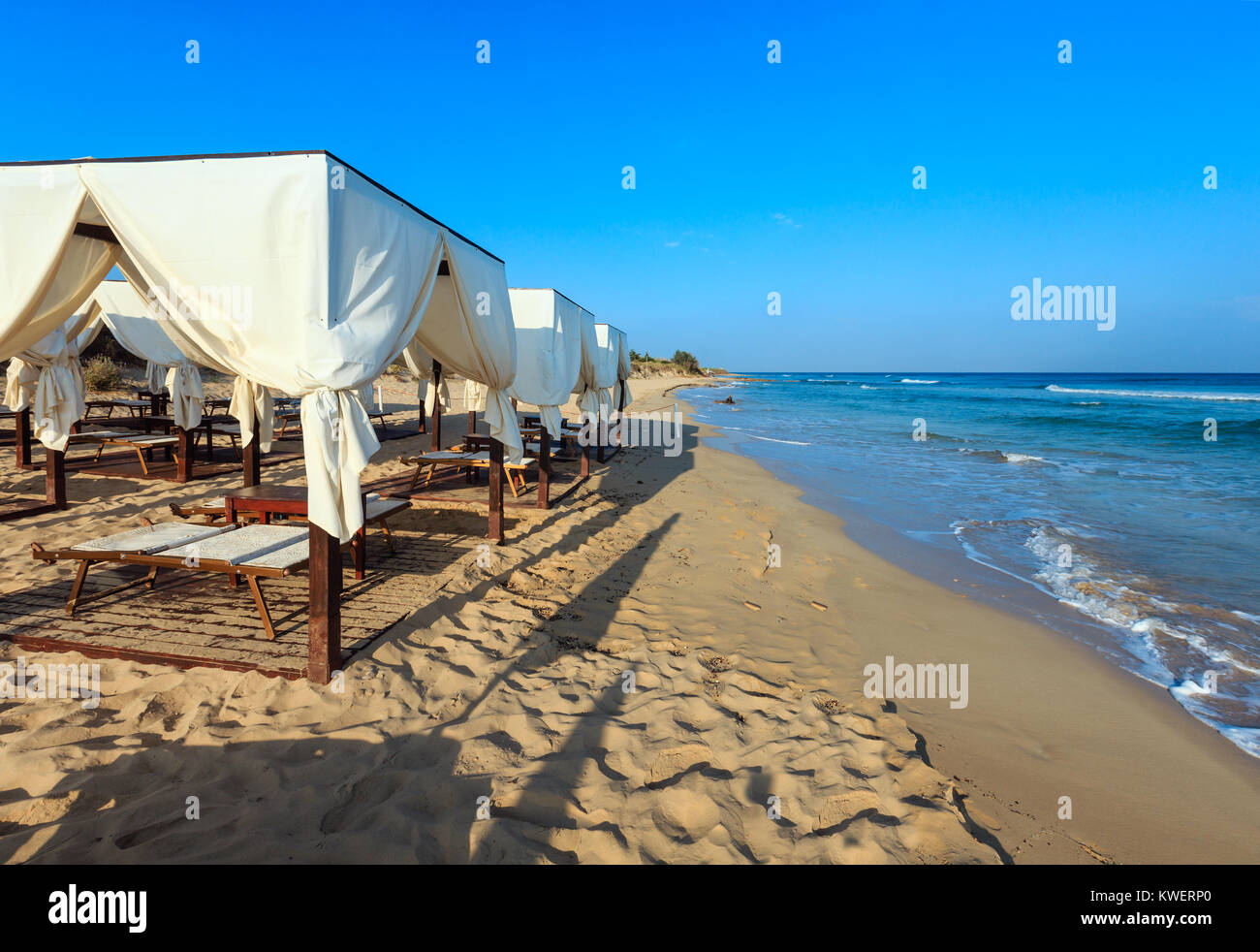 Les auvents tentes de luxe plage paradis matin sur une plage de sable blanc des Maldives (Salento Pescoluse, Salento, Pouilles, Italie du sud). Le plus beau se Banque D'Images