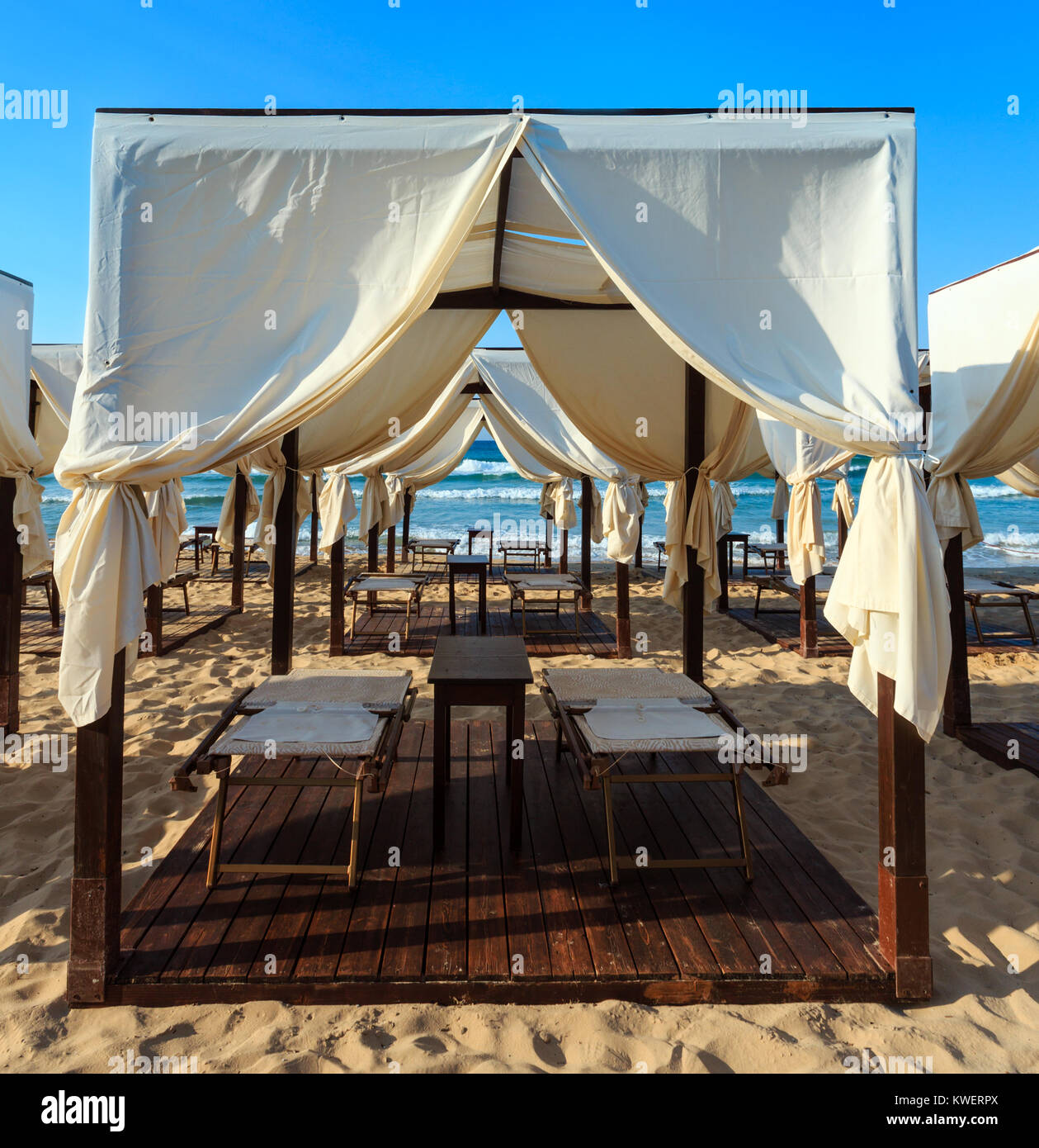 Les auvents tentes de luxe plage paradis matin sur une plage de sable blanc ( Salento, Pouilles, Italie du sud).La plus belle plage de sable fin de la mer des Pouilles. Banque D'Images