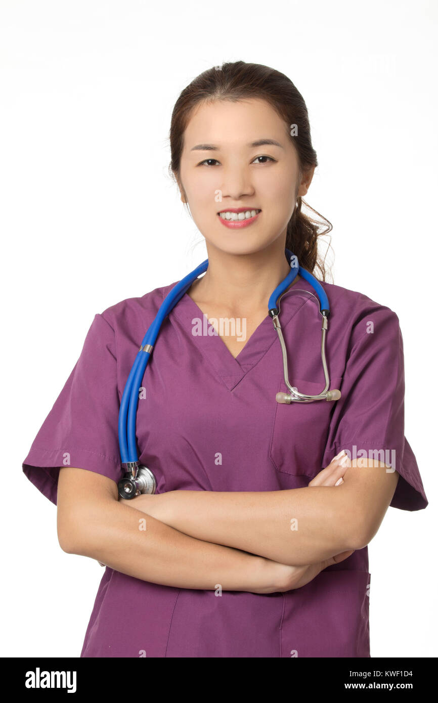 Belle Asiatique-américain médecin ou infirmière wearing blue scrubs et posant avec stéthoscope isolé sur fond blanc Banque D'Images