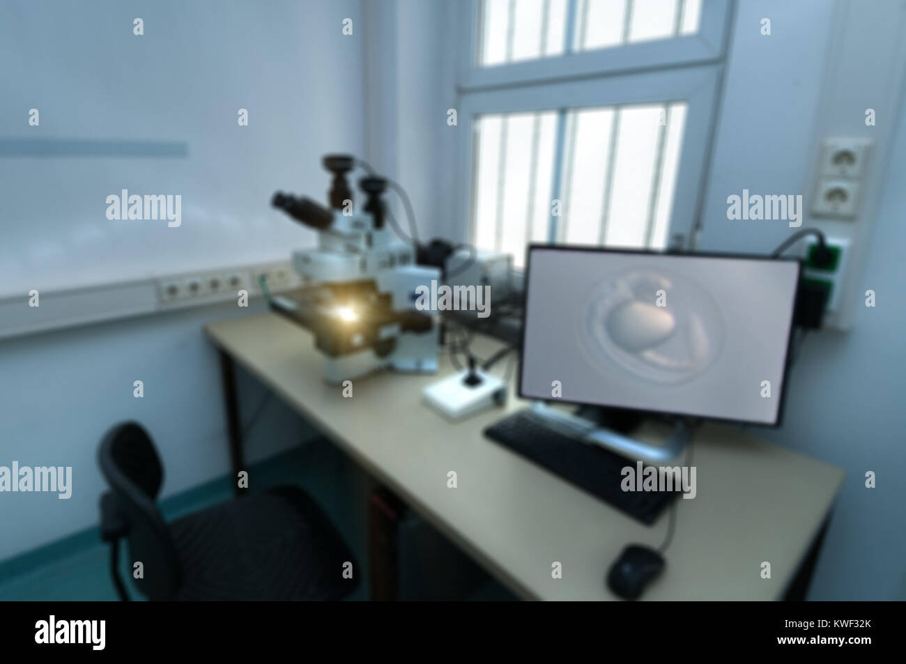 Arrière-plan scientifique avec microscope moderne gare hors de concentration ; l'embryon de poisson-zèbre à l'écran Banque D'Images