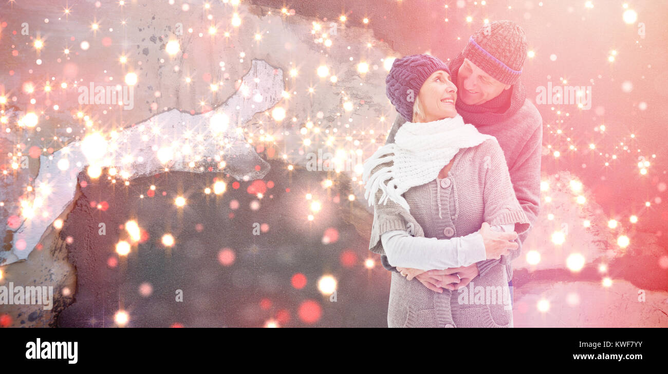 Image composite de mature woman in winter clothes embracing Banque D'Images