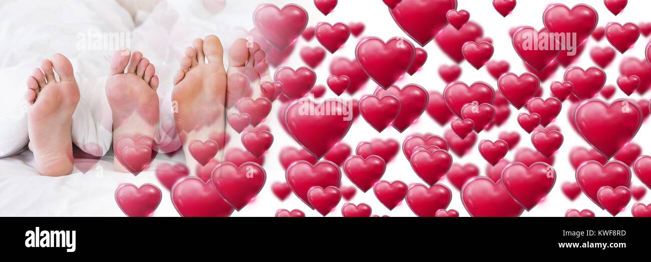Pieds de couple dans le lit avec coeur de transition amour de Valentin Banque D'Images