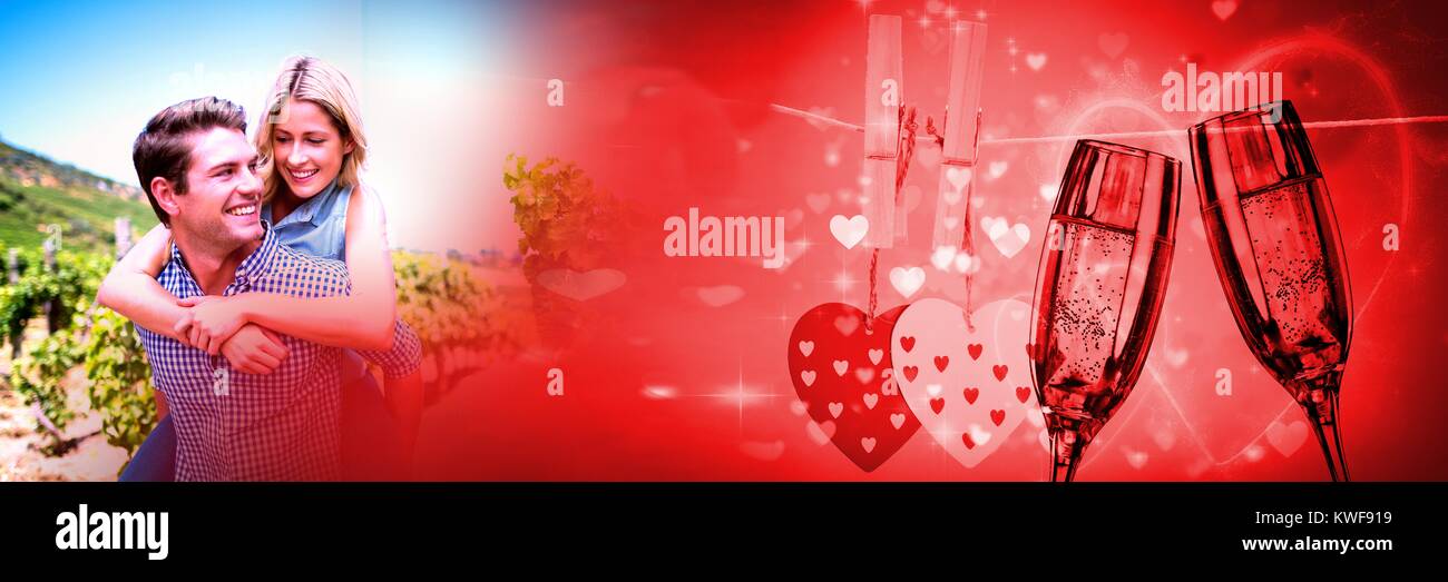 Couple qui donne le pigegyback avec la transition amour de la Valentin et des verres à champagne et les cœurs Banque D'Images