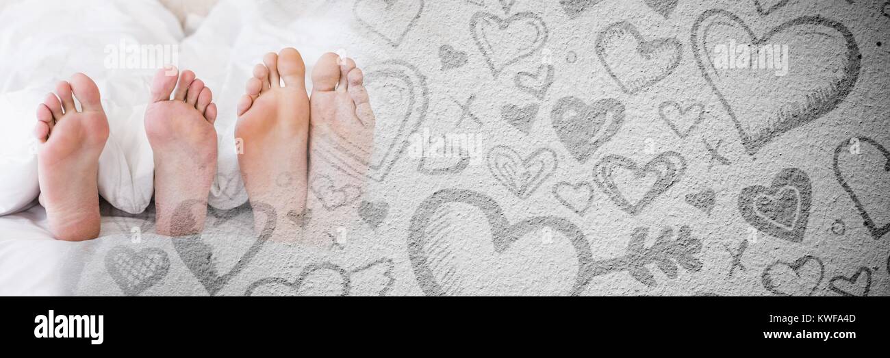 Pieds de couple dans le lit avec coeur de transition amour de Valentin Banque D'Images