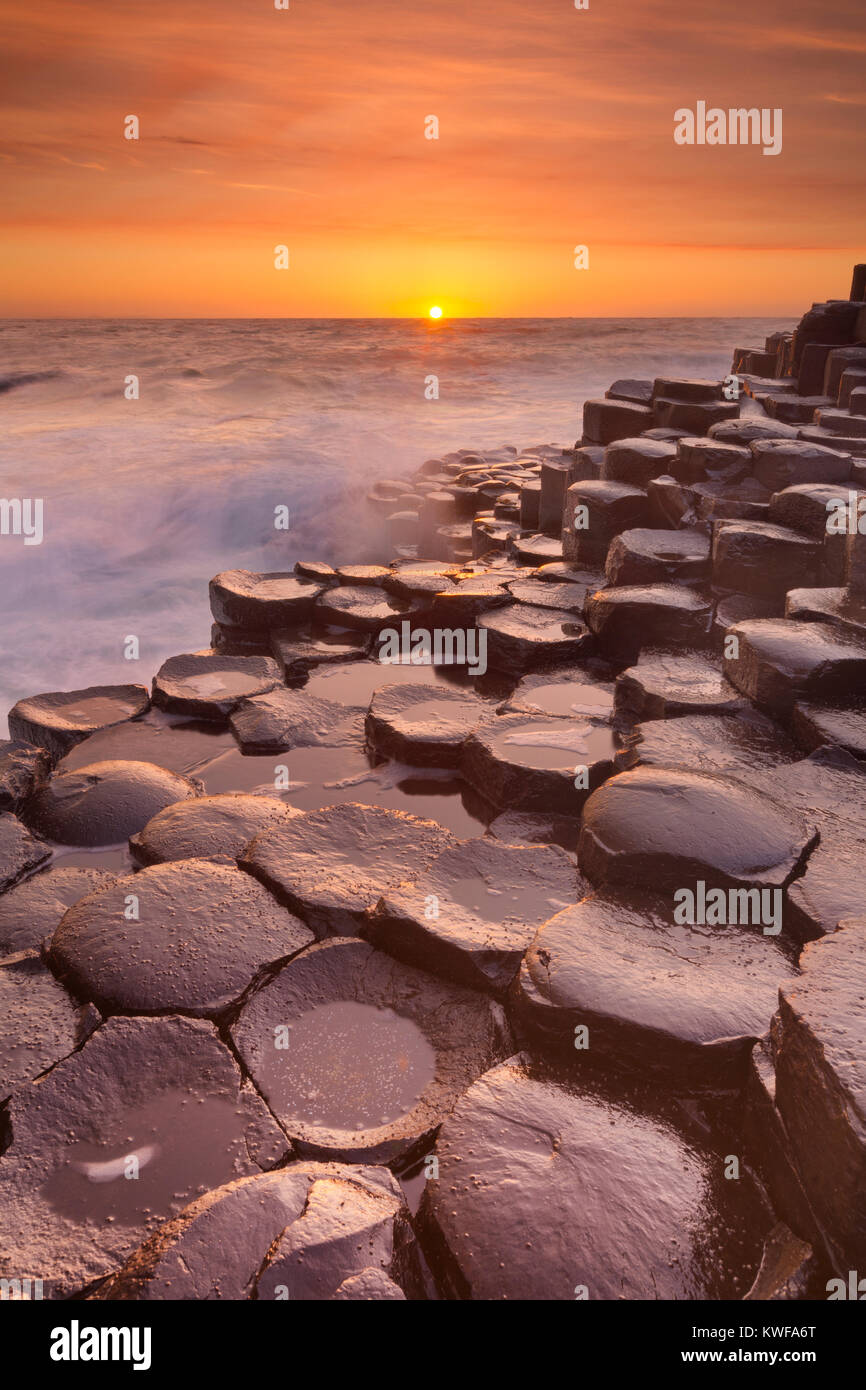 Coucher de soleil sur la roche de basalte de la Chaussée des géants sur la côte nord de l'Irlande du Nord. Banque D'Images