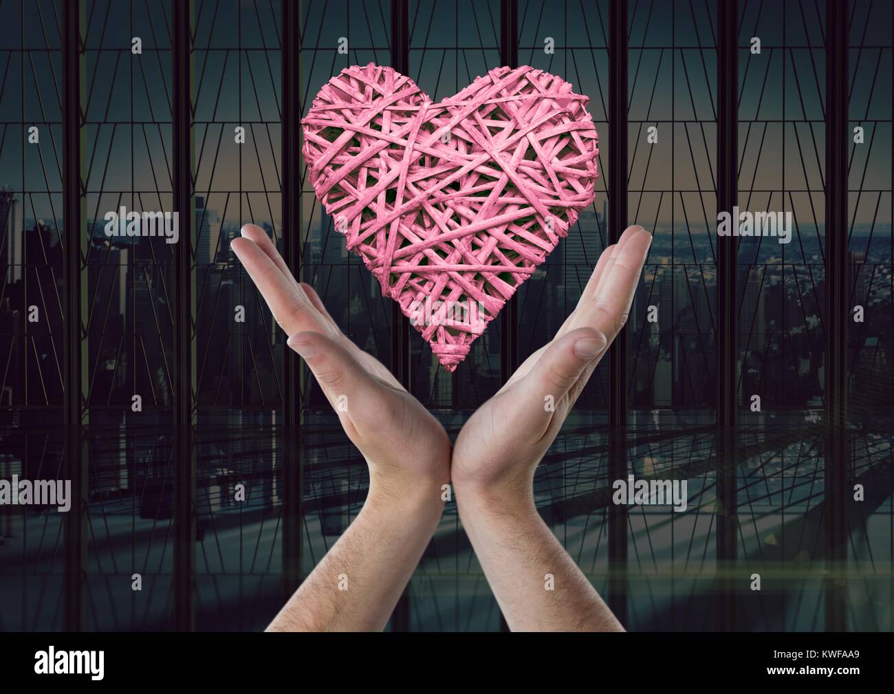 Femme avec les mains ouvertes et le coeur par la fenêtre de bureau Banque D'Images