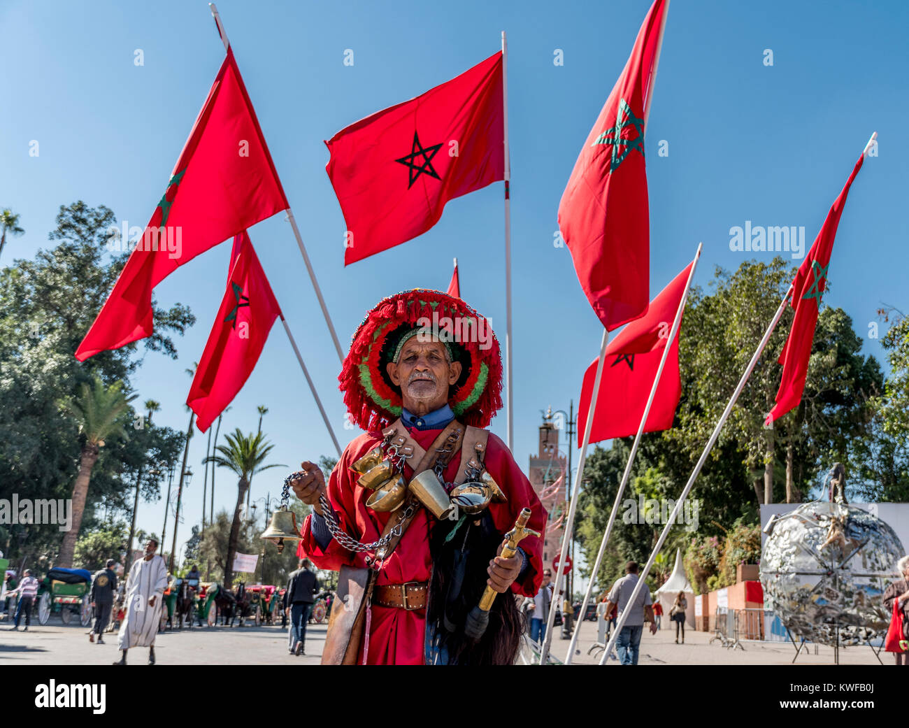 Vendeur d'eau traditionnels et la Koutoubia avec drapeau marocain. Banque D'Images