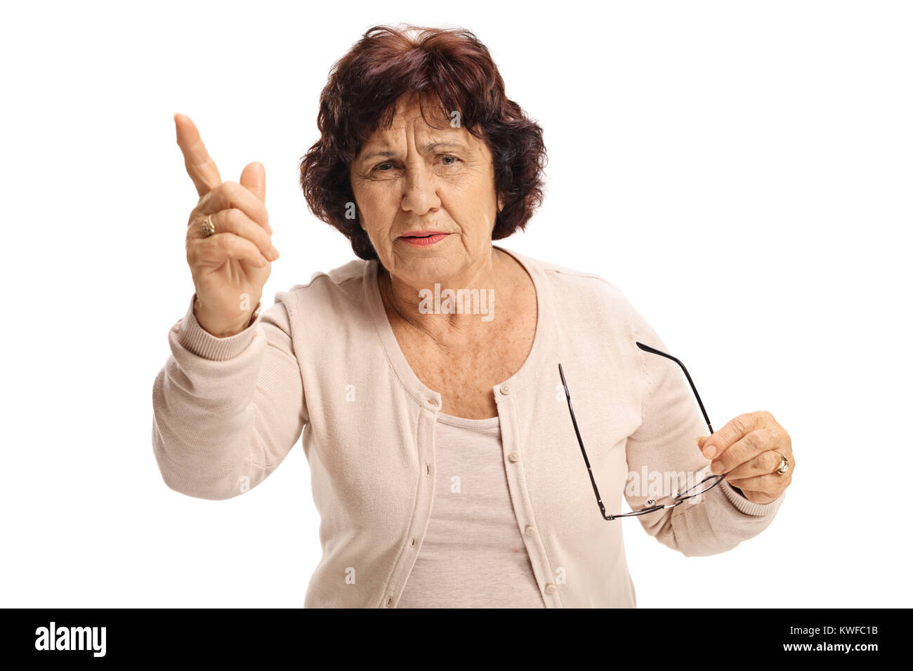 Vieille Femme en colère les réprimandes quelqu'un et gesticulant avec son doigt isolé sur fond blanc Banque D'Images