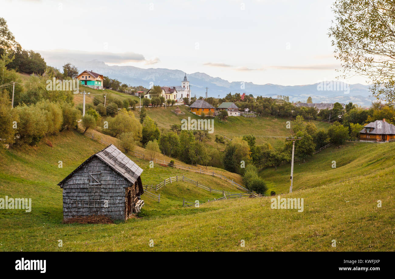 Magura village et vue sur les contreforts des montagnes des Carpates dans le parc national de Piatra Craiului, Transylvanie, Roumanie, dans la lumière du matin Banque D'Images