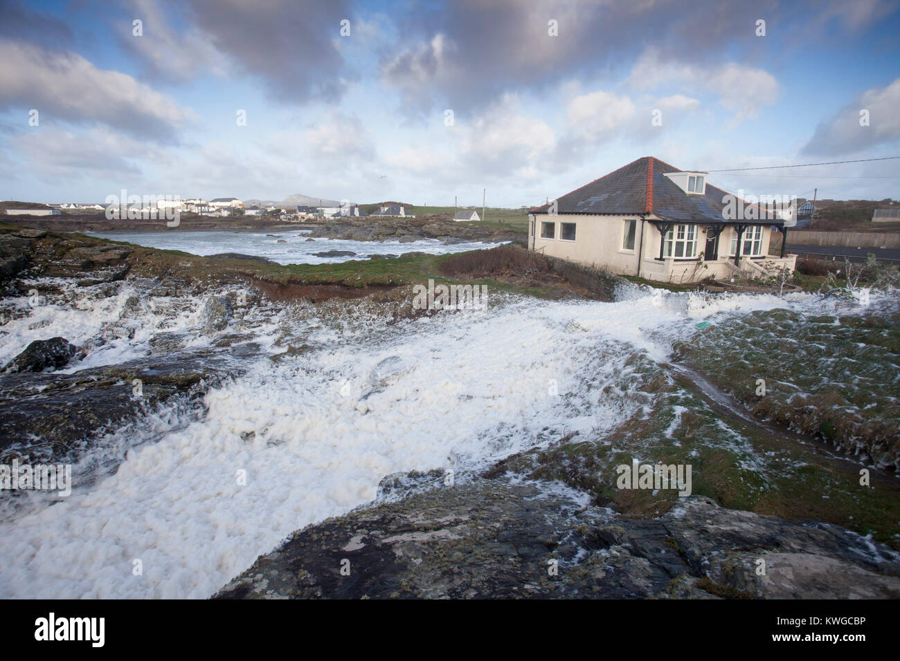 L''Anglesey, au Pays de Galles, 3 janvier 2018. Météo britannique. Un avertissement sévère Met Office a été émis pour la cinquième tempête de la saison britannique nommé Storm Eleanor. Avec une augmentation de risque en raison de l'état actuel de la lune, des marées et des avertissements d'inondation sont en place pour de nombreux domaines avec des vents de force coup de vent susceptible de causer un préjudice. Des vagues énormes et les vents s'écrasent dans la baie de Trearddur sur Anglesey, au nord du Pays de Galles comme l'écume de mer est sur le point d'embraser une maison proche de la mer © AlamyLive News Banque D'Images