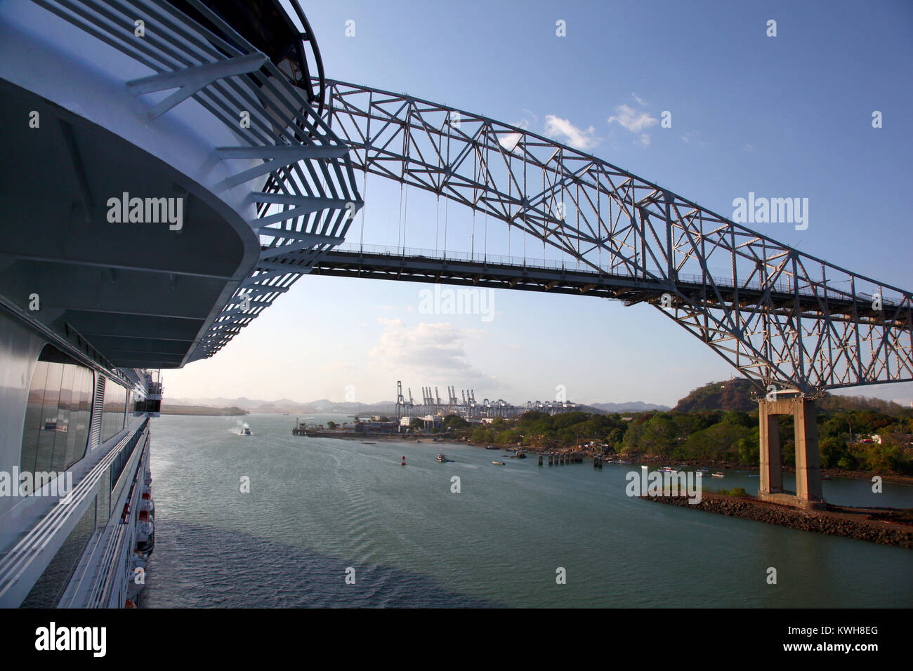 Bateau de croisière qui passe sous le Pont des Amériques, avec un important port d'expédition dans l'arrière-plan, Canal de Panama. Banque D'Images