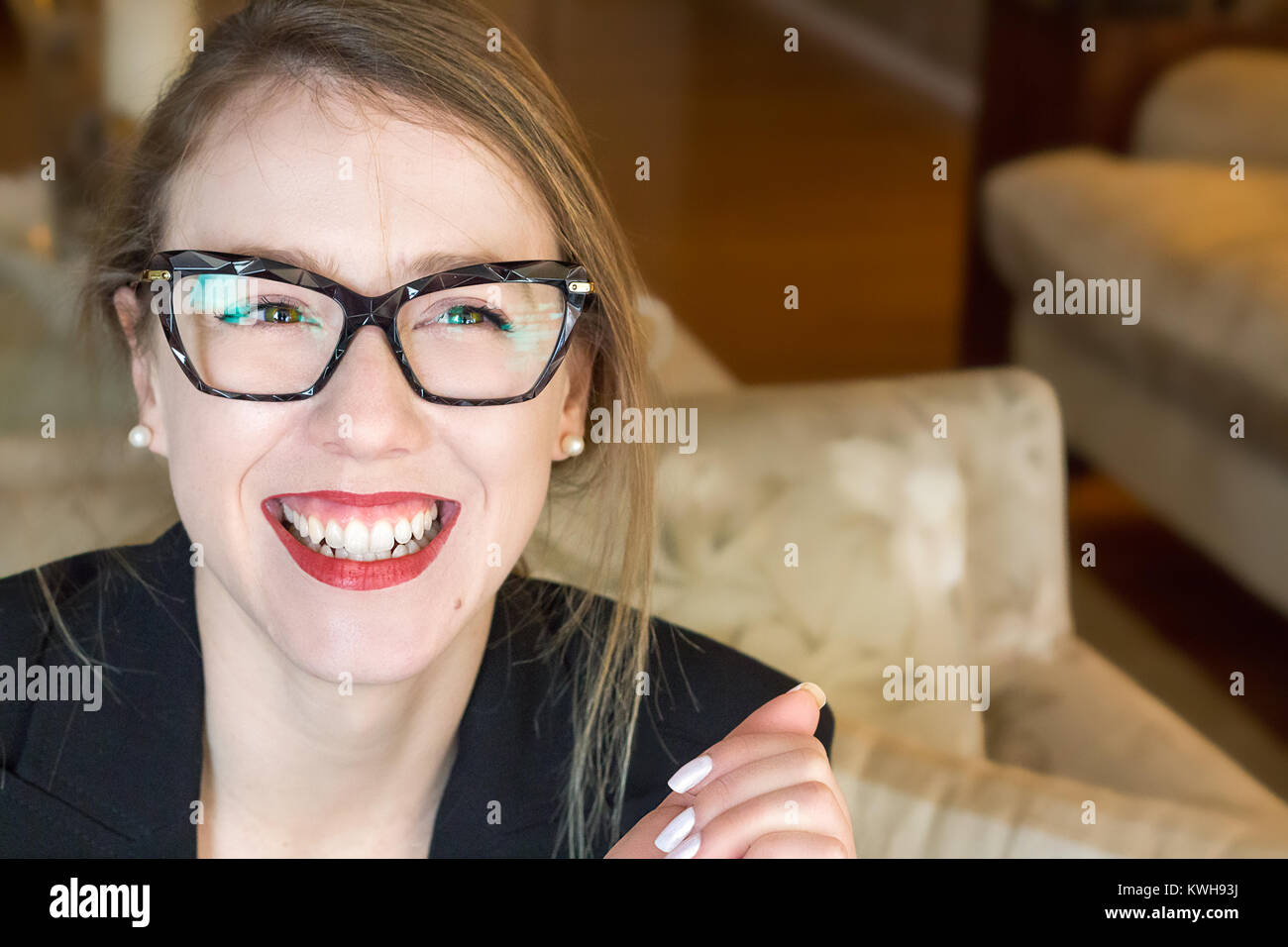 Portrait d'une jeune femme blonde portant des lunettes Vue de face, souriant, heureux, libre, lumière naturelle, à l'intérieur. Banque D'Images