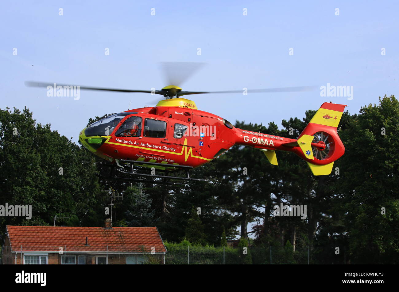 Midlands Air Ambulance en arrivant sur le village vert dans Fernhill Heath le Worcestershire à assister à une situation d'urgence. Banque D'Images