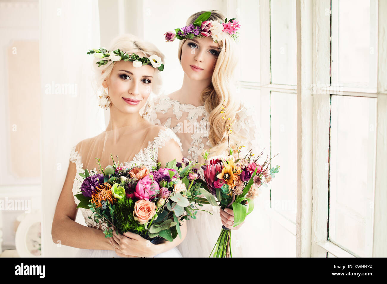 Deux mariée parfaite. Les femmes blondes avec bouquet de fleurs, gerbe, mariage Coiffure et maquillage Banque D'Images