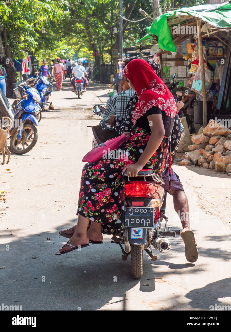 Femme musulmane équitation leurs sur une moto à Dala Township, dans l'ensemble du fleuve Yangon à partir de Yangon. Banque D'Images