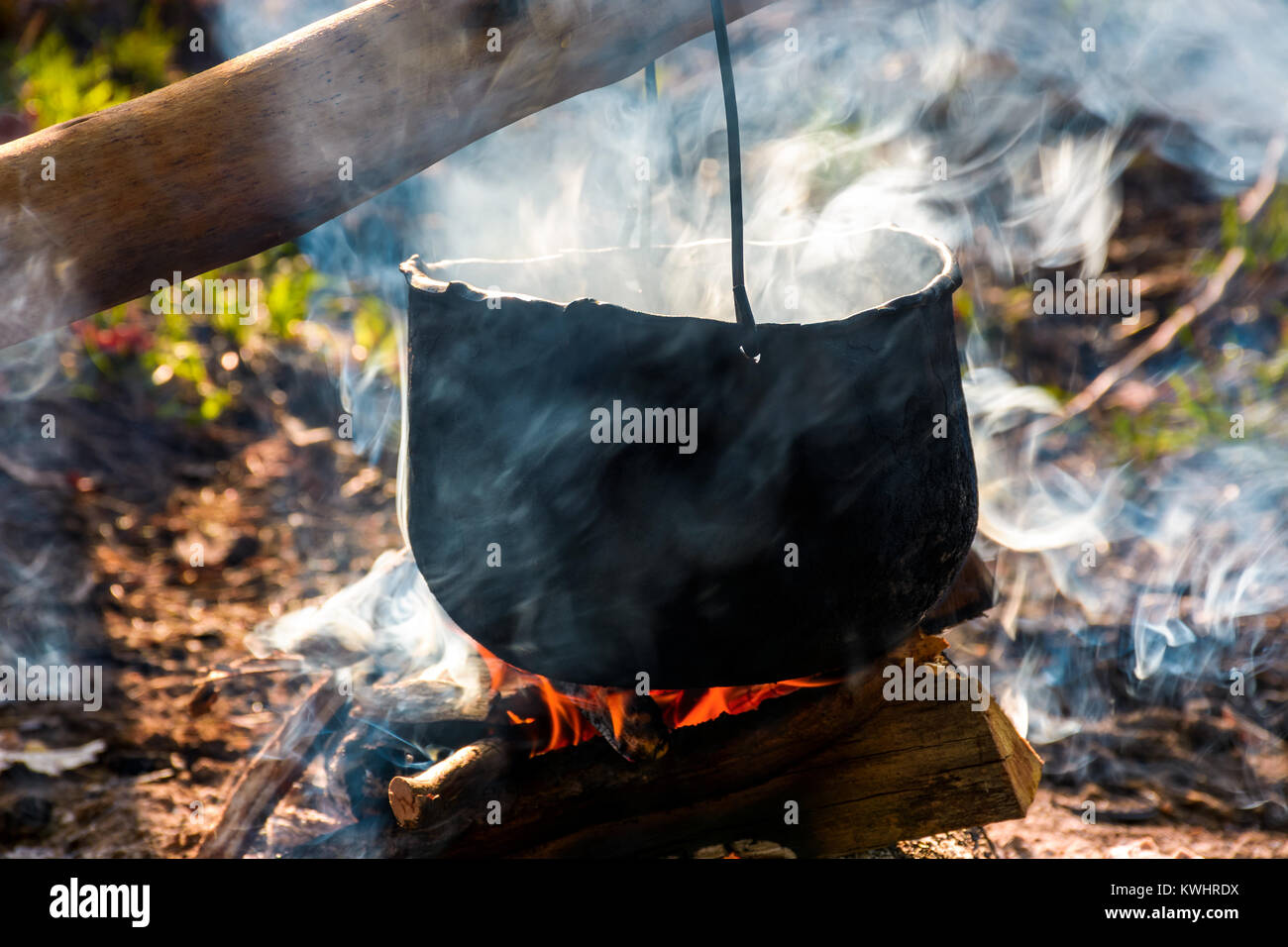 Chaudron à vapeur et la fumée sur feu ouvert. Cuisine de plein air concept. vieille façon de faire de l'alimentation Banque D'Images