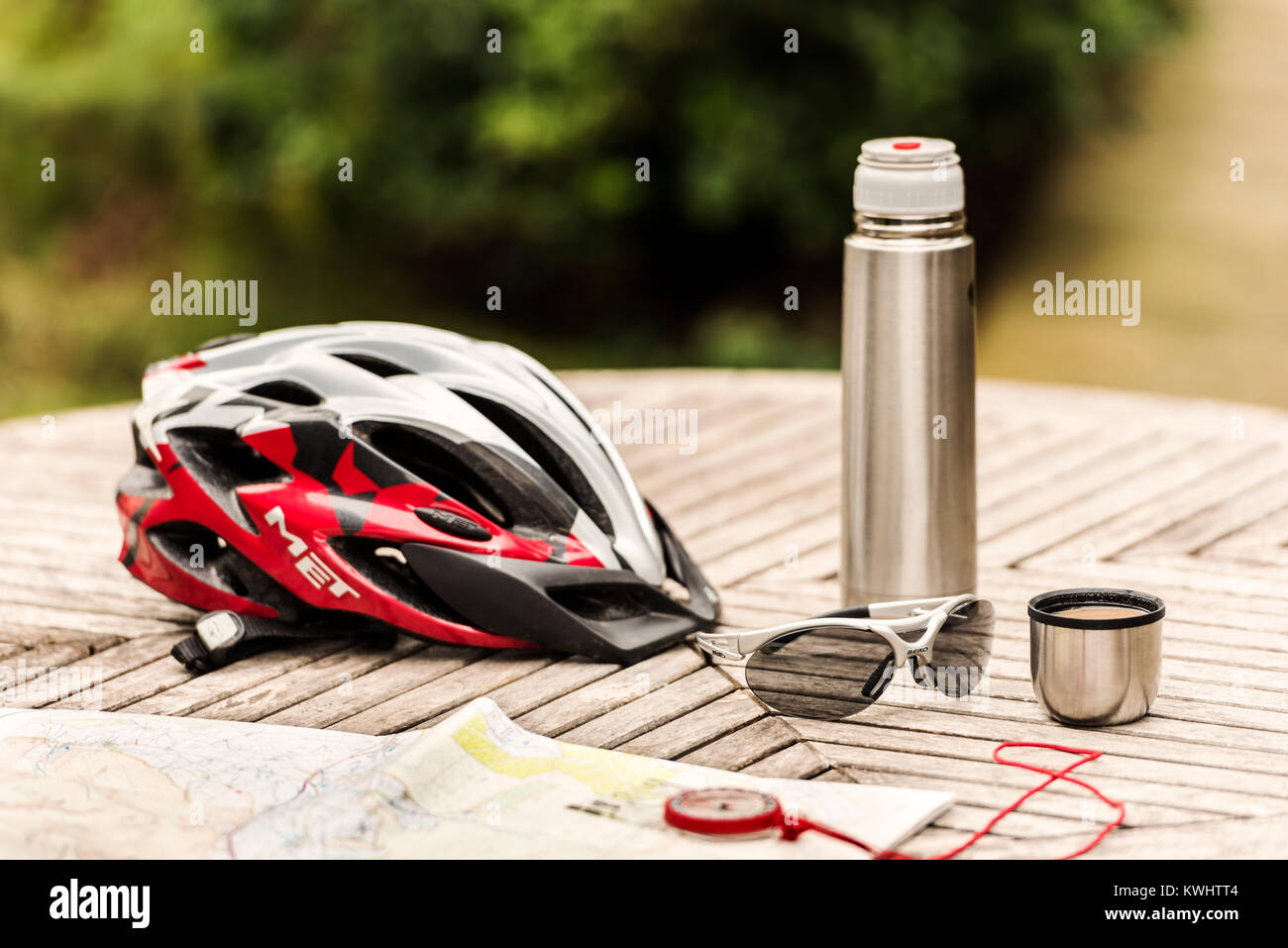 Casque de vélo et verres sur table avec ballon de café et carte. Banque D'Images