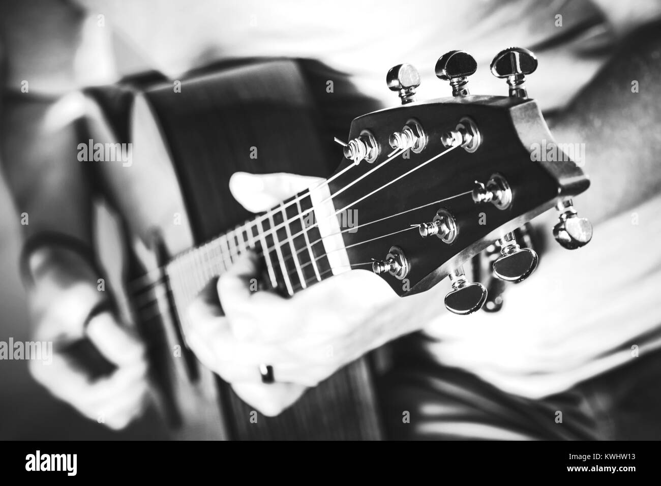 La Photographie noir et blanc de musicien jouant sur une guitare acoustique. Libre avec une faible profondeur de champ. Performance de guitare. Banque D'Images