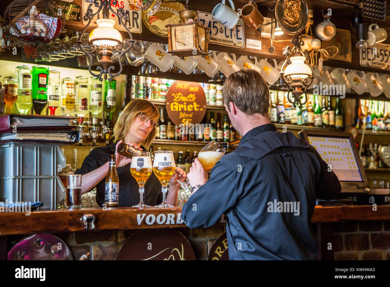 Barmaid et waiter pouring bières belges dans des verres à bière en flamand café De Dulle Griet dans la ville de Gand, Flandre orientale, Belgique Banque D'Images