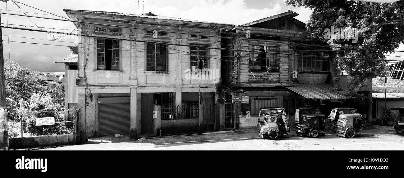 De vieux bâtiments avec des tuk-tuks en face d'elle en Majayjay, Philippines Banque D'Images